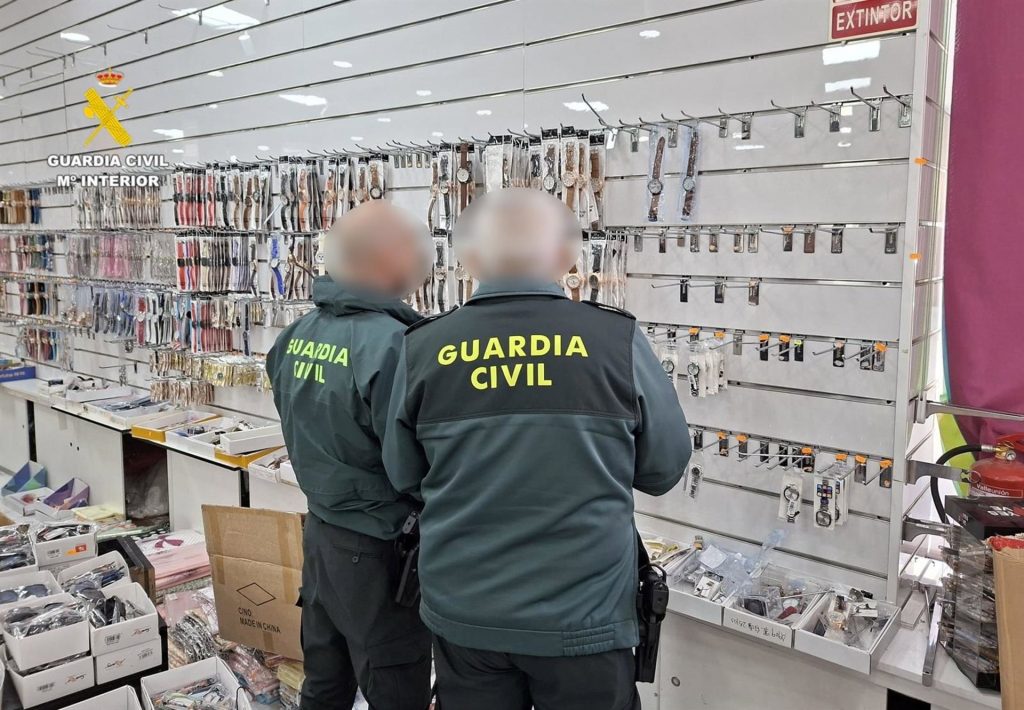 Dos agentes desarticulando las falsificaciones - GC